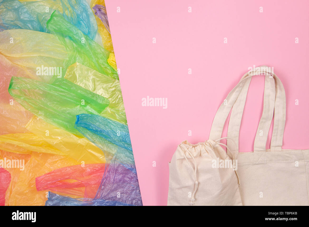 Viele bunte Plastiktüten mit Eco Natural wieder verwendbare Einkaufstaschen auf rosa Hintergrund. Null Abfall, Umweltfreundlich, kein Plastik Konzept Stockfoto