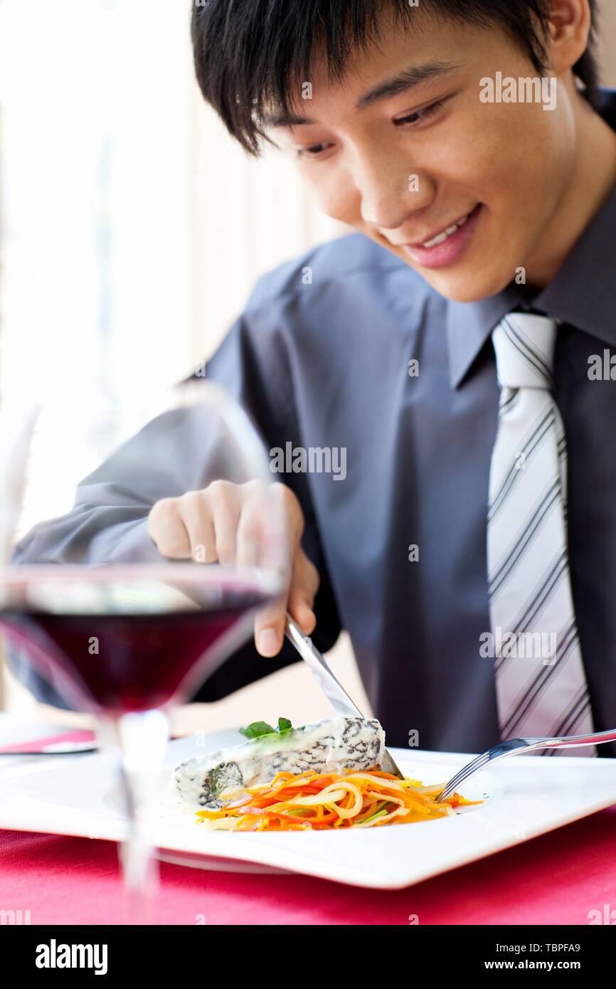 Creative Foto: Ein junger Mann genießt ein Abendessen in einem Restaurant in Shanghai, China. Stockfoto