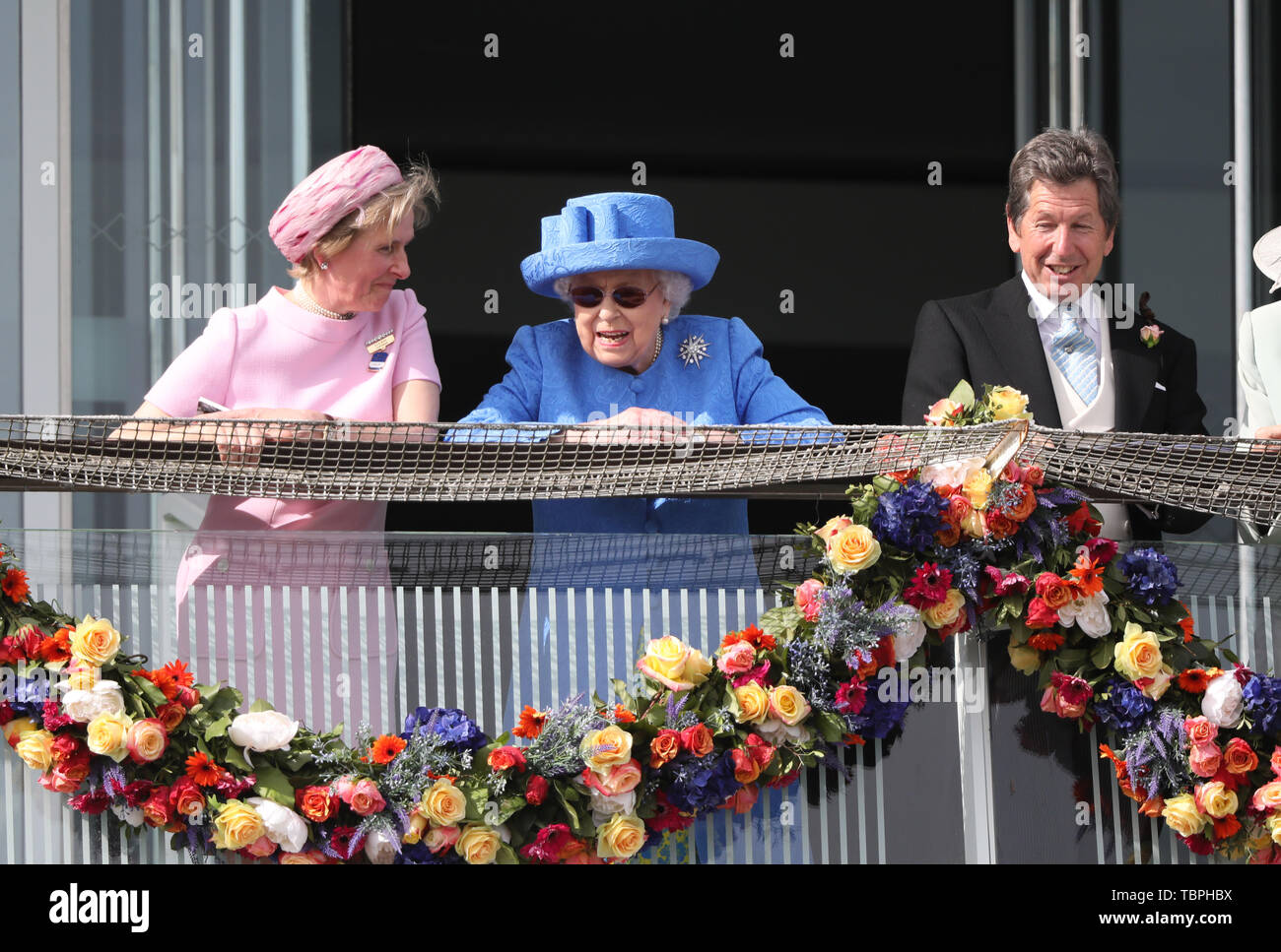 Königin Elizabeth II. ist alles Lächeln, wie sie Uhren der Investec Epsom Derby Pferderennen neben ihrem Horse Racing Manager John Warren und Julia Budd Epsom Rennbahn Vorsitzender, Epsom, Surrey, UK am 1. Juni 2019. Stockfoto