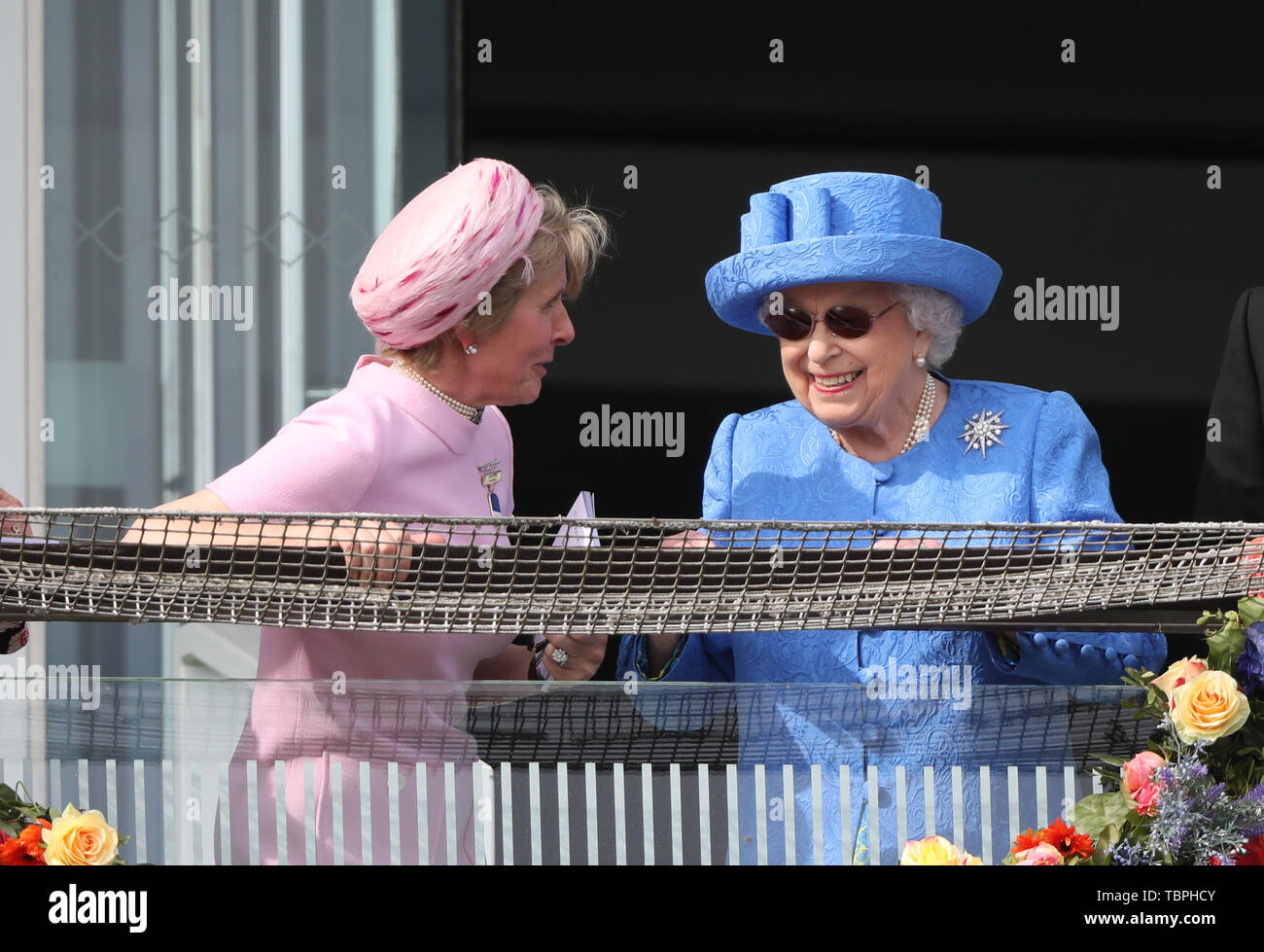 Königin Elizabeth II. ist alles Lächeln, wie sie Uhren der Investec Epsom Derby Pferderennen neben Julia Budd Epsom Rennbahn Vorsitzender, Epsom, Surrey, UK am 1. Juni 2019. Stockfoto