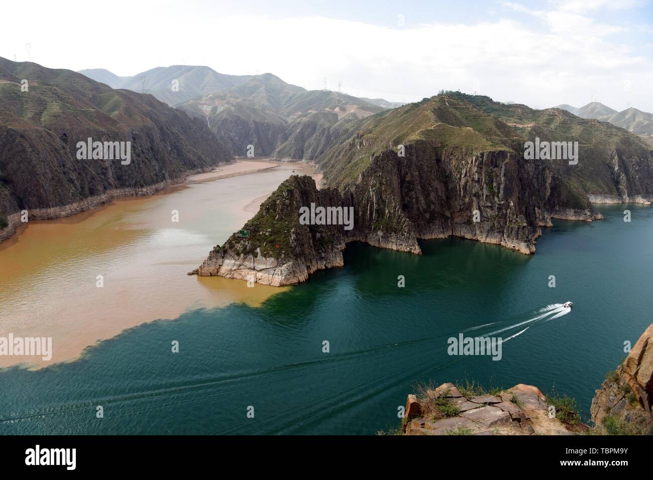 Peking, China. 2. Juni 2019. Foto am 2. Juni 2019 zeigt eine Yacht segeln im Stausee in Liujiaxia Yongjing County im Nordwesten der chinesischen Provinz Gansu. Ein scharfer Kontrast der Farben ist klar gezeigt, wenn zwei Flüsse, Schlamm-Gelben Fluss und seinen Beiträgen Taohe Fluss, fließt mit einer großen Menge von Schlamm und Sand in der Liujiaxia Behälter, die weit verbreitet ist - für sein klares Wasser bekannt. Quelle: Ma Ning/Xinhua/Alamy leben Nachrichten Stockfoto
