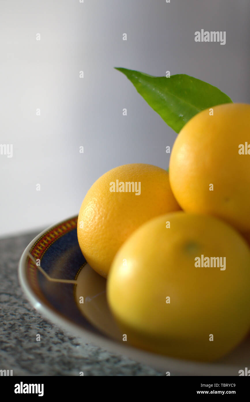 Frisch geschnittenen Orangen auf einem tiefen Teller mit hellen Hintergrund. Close Up. Stockfoto