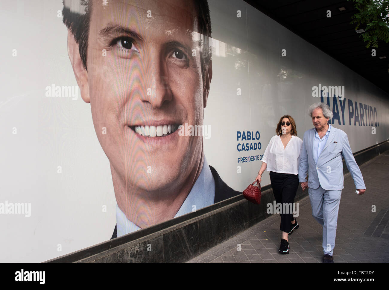 Fußgänger vorbei an einem großen Bild von Pablo Casado, der Führer des Partido Popular (PP) in der Zentrale der Partei vor dem Lokal, Regional- und Europawahlen. Stockfoto