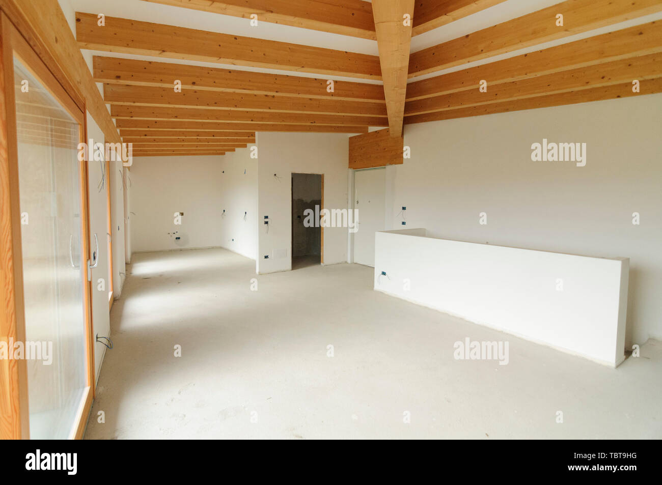 Bau oder Renovierung im Gange: Leere offenen Raum mit großen Fenstern und Holzbalken Stockfoto