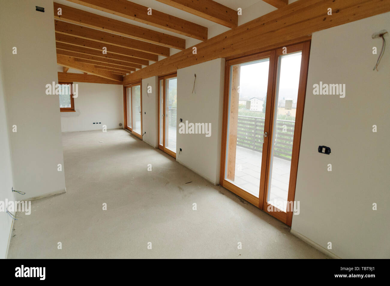 Bau oder Renovierung im Gange: Leere offenen Raum mit großen Fenstern und Holzbalken Stockfoto