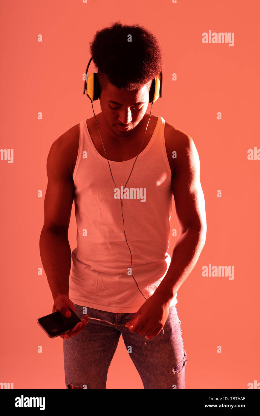 Künstlerische Portrait von starken afrikanischen amerikanischen Jungen Tänzer oder DJ Kopfhörer bereit zu Spielen oder Tanzen in der Disco Tanzfläche Neonlicht im Internet Mus Stockfoto