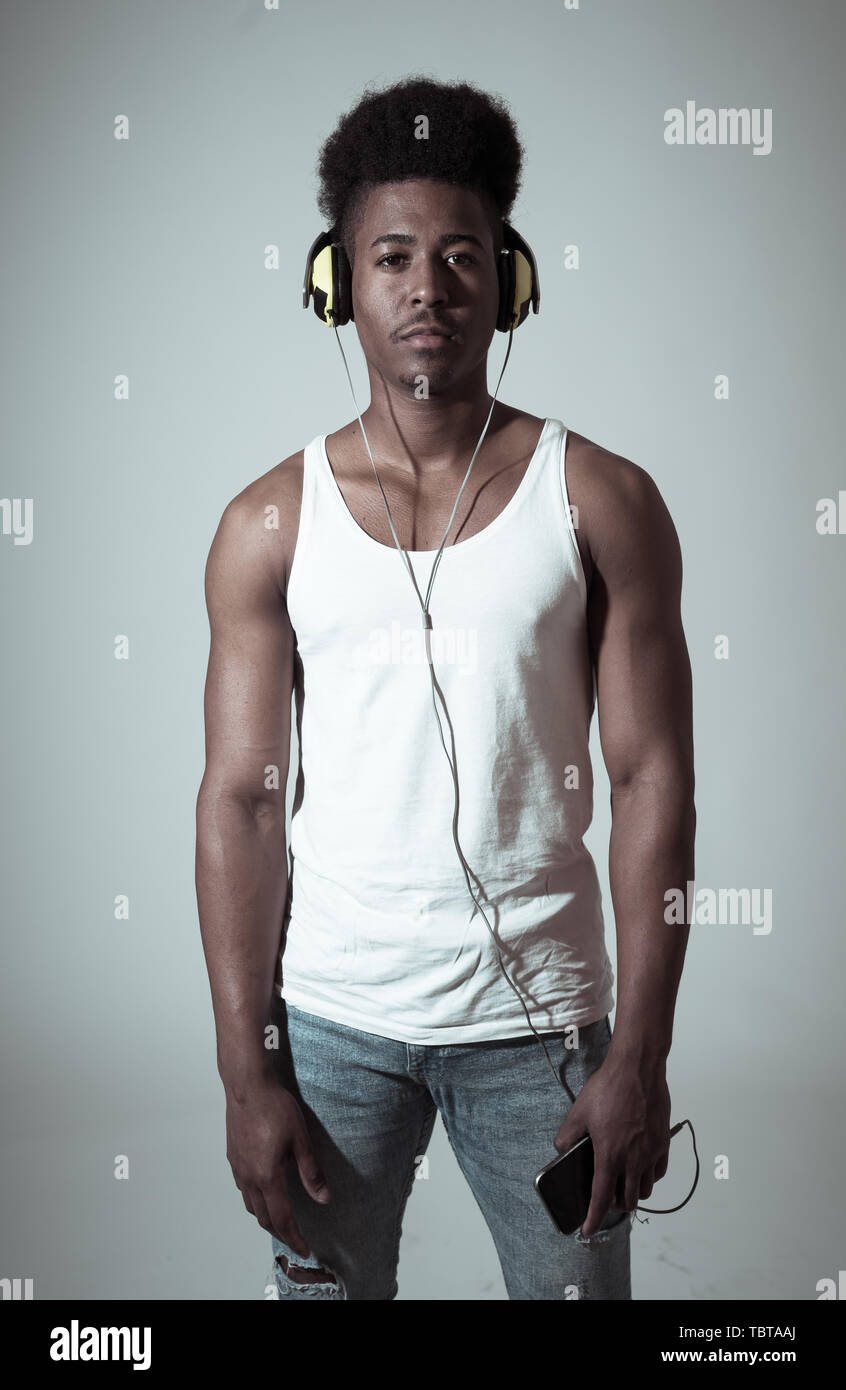 Künstlerische Portrait von starken afrikanischen amerikanischen Jungen Tänzer oder DJ Kopfhörer bereit zu Spielen oder Tanzen in der Disco Tanzfläche Neonlicht im Internet Mus Stockfoto