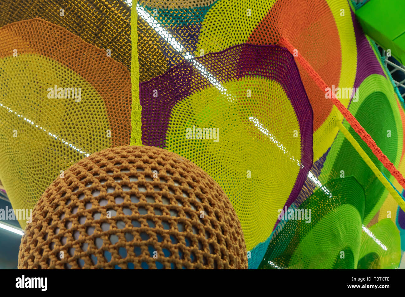 Gummiball, mit braunem Gitter abgedeckt. Abstrakte Textur von mehrfarbigen Gewebe. Kreative vintage Hintergrund Stockfoto