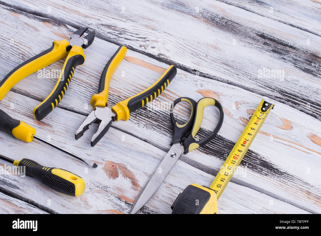 Einstellen der Werkzeuge auf Holz- Hintergrund. Zange, Schraubenzieher, Schere und Maßband. Tools für Builder oder Klempner. Stockfoto