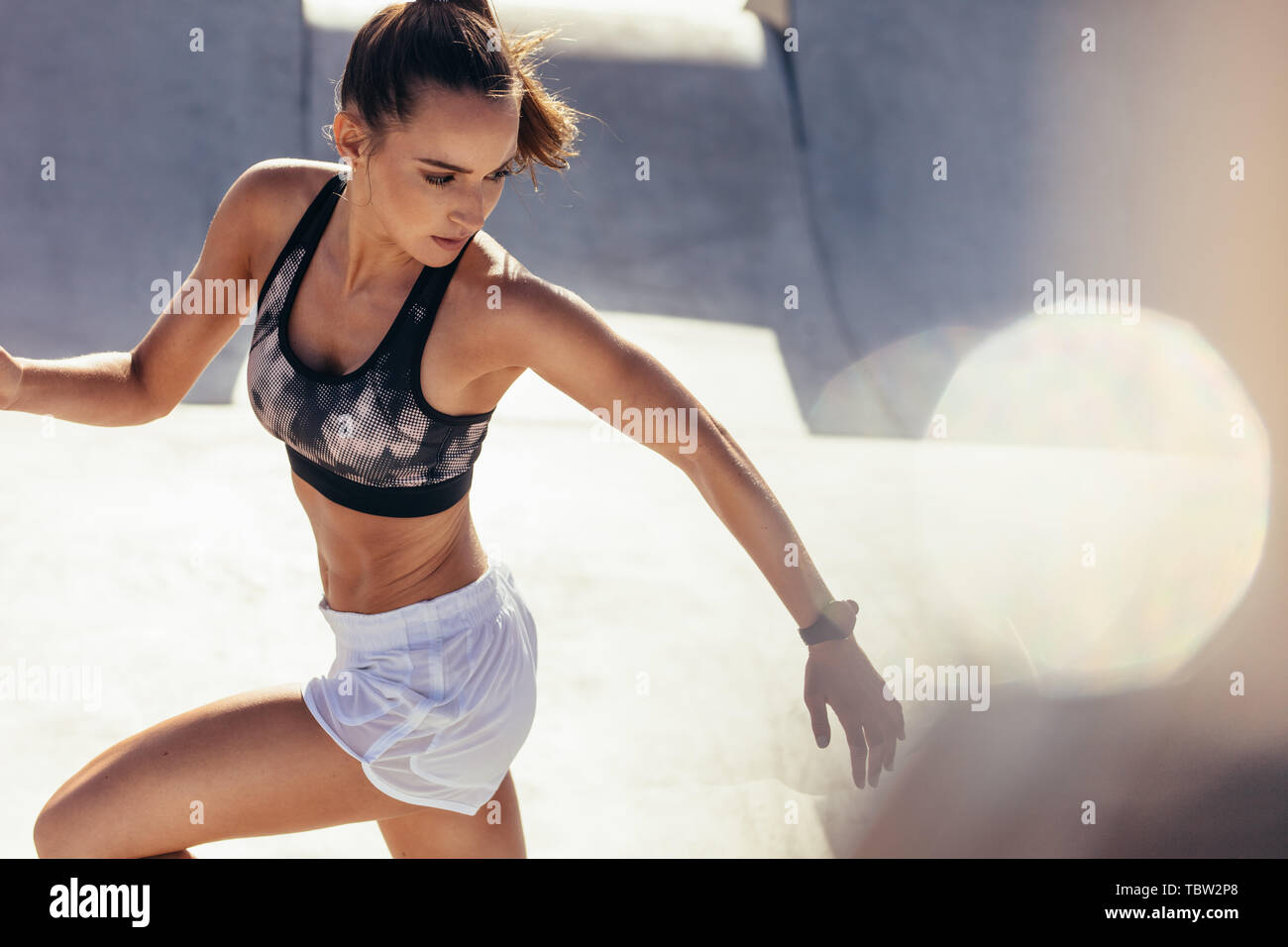 Passen junge Frau läuft am Morgen. Gesundheitsbewusste Frau tun Lauftraining im Freien. Stockfoto