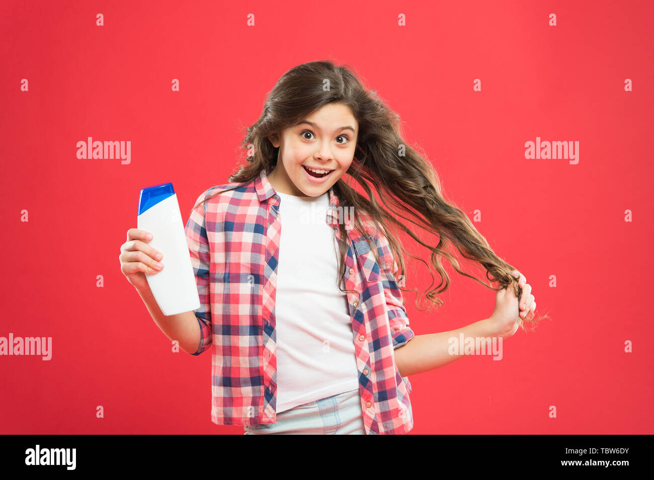 Trocken Shampoo. Einfache Tipps, die Frisur für Kinder. Starkes und  gesundes Haar Konzept. Lang anhaltende Frische. Es Frisch. Kleines Kind  lange Haare. Mädchen aktiv Kid mit langen Haaren. Shampoo Flasche  Stockfotografie -