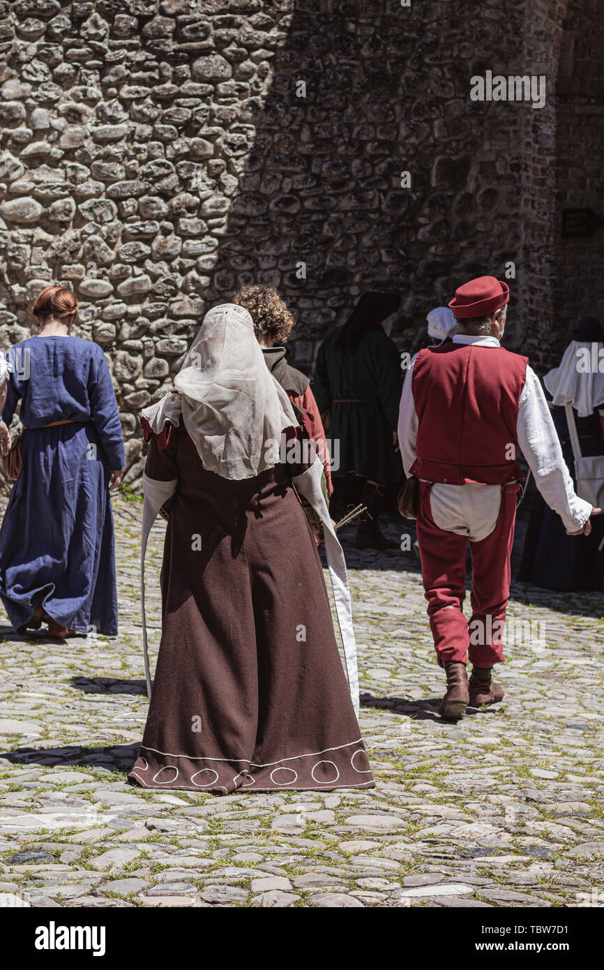Gruppe der unkenntlich Menschen in mittelalterlichen Kostümen auf einer alten Straße Stockfoto