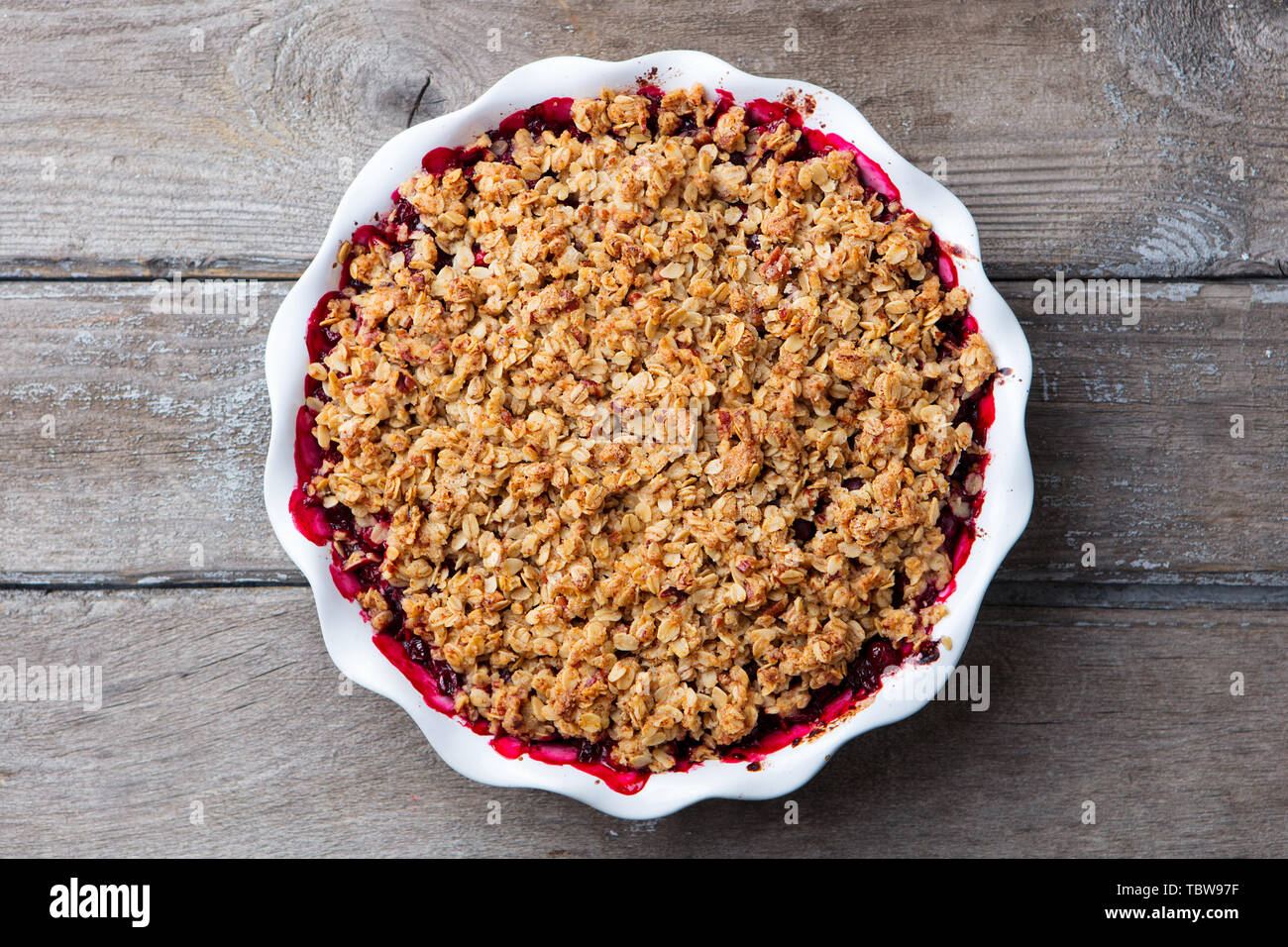 Berry crumble, gestochen scharf in der auflaufform. Holz- Hintergrund. Ansicht von oben. Stockfoto