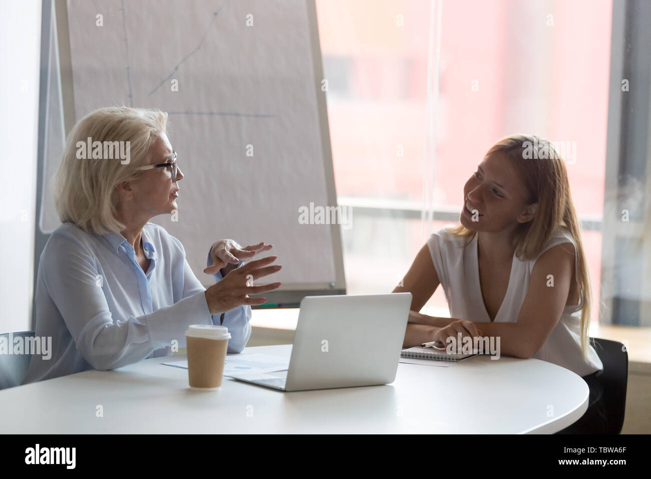 Reife Geschäftsfrau Mentor im Gespräch mit weiblichen intern im Konferenzraum. Stockfoto