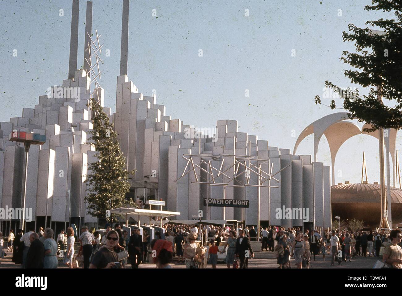 Massen von Menschen, an einem sonnigen Tag, außerhalb der Turm des Lichts Pavillon, 1964 in New York World's Fair, Flushing Meadows Park, Queens, New York, Juni, 1964. () Stockfoto