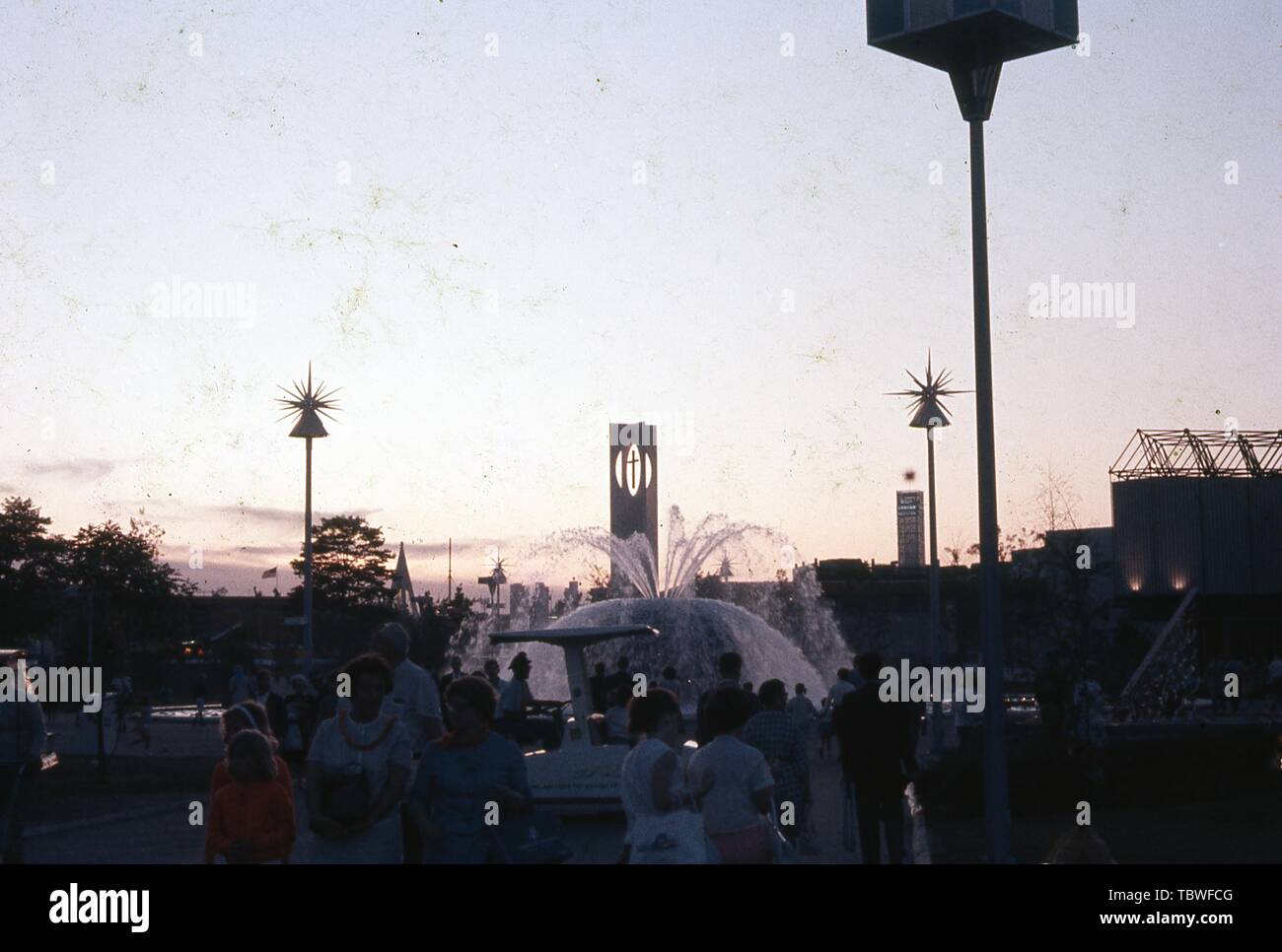 Abend geschossen von messebesuchern in der Nähe von einem Brunnen, mit der evangelischen und orthodoxen Zentrum Turm im Hintergrund, 1964 in New York World's Fair, Flushing Meadows Park, Queens, New York, Juni, 1964. () Stockfoto