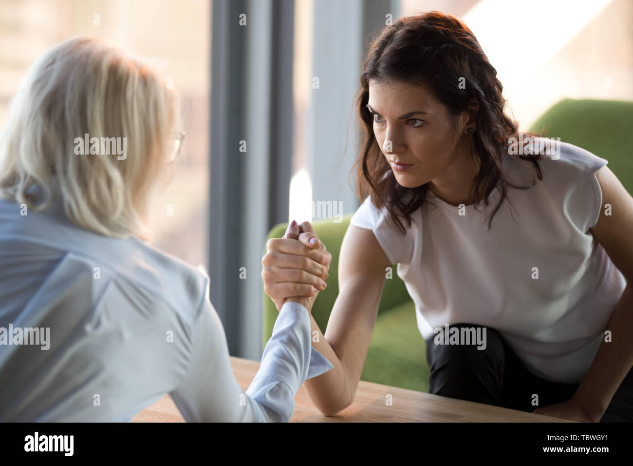 Konzentrierte sich Frau arm mit Kollegen demonstrieren die Macht zu kämpfen. Stockfoto