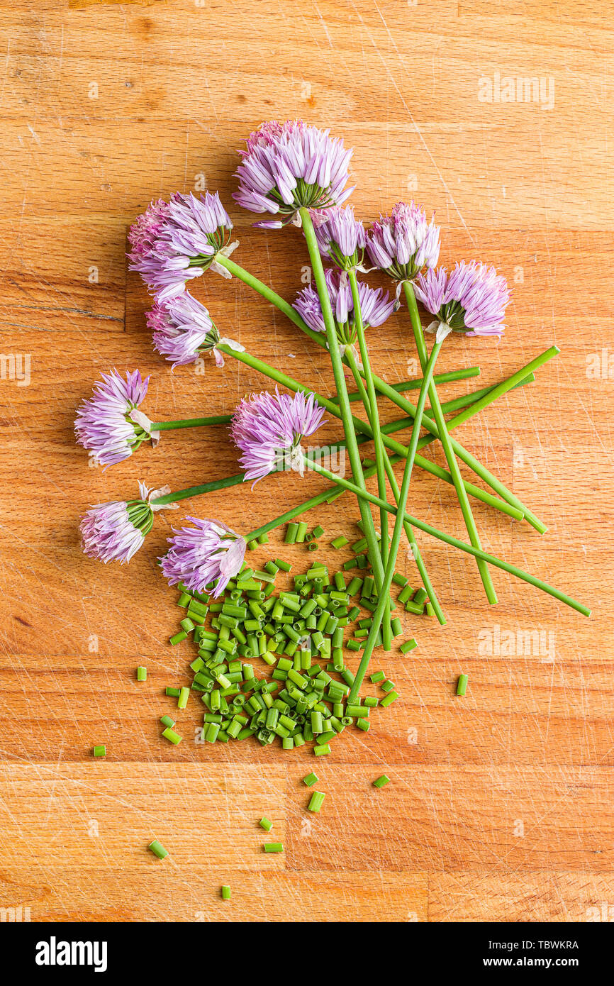 Gehackten Schnittlauch mit Blumen auf alten Küchentisch. Stockfoto