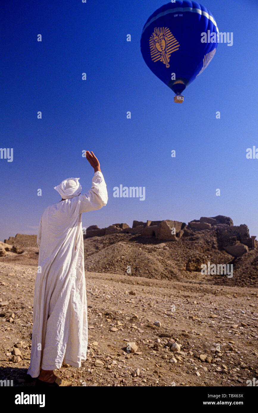 Foto: © Simon Grosset. Ballonfahrten über das Tal der Könige, Luxor, Ägypten. Ein ägyptischer in traditionelle Kleidung Wellen auf den Ballon. Archiv: Stockfoto