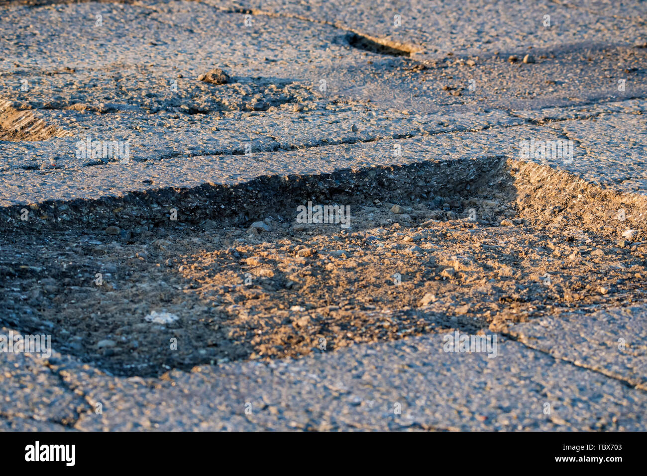 In der Nähe von Loch in unebenen Asphalt außerhalb Stockfoto