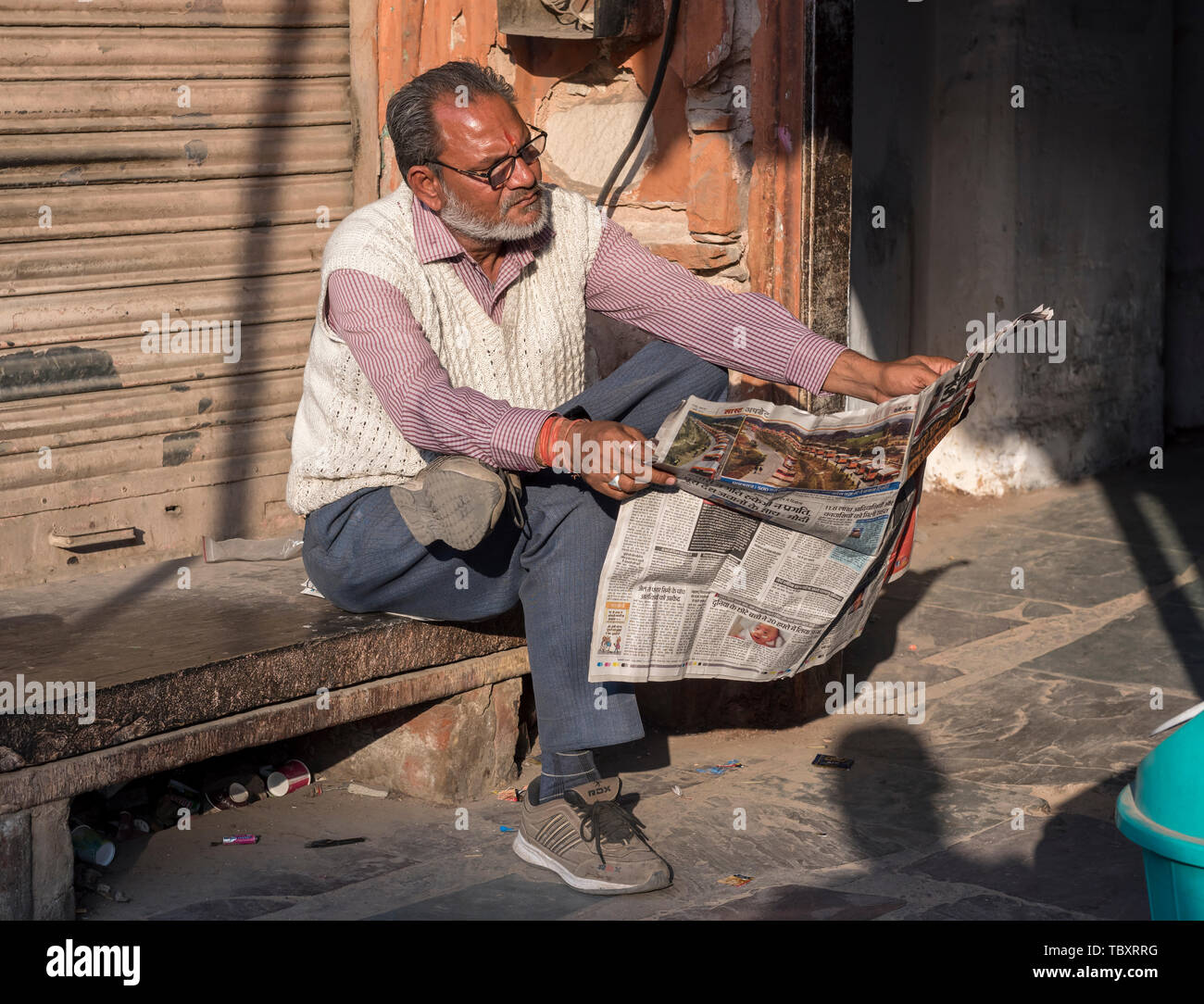 Indische Mann liest Zeitung, Altstadt von Jaipur, Rajasthan, Indien Stockfoto