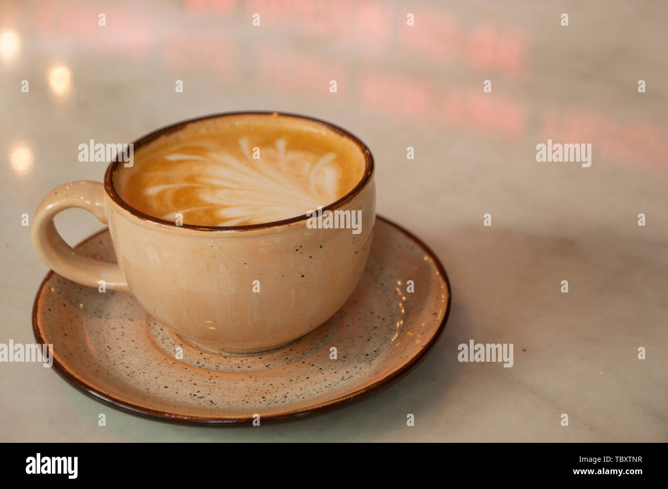 Tasse Cappuccino mit schönen Latte Art auf einem Tisch in einem Cafe mit Copyspace. Stockfoto