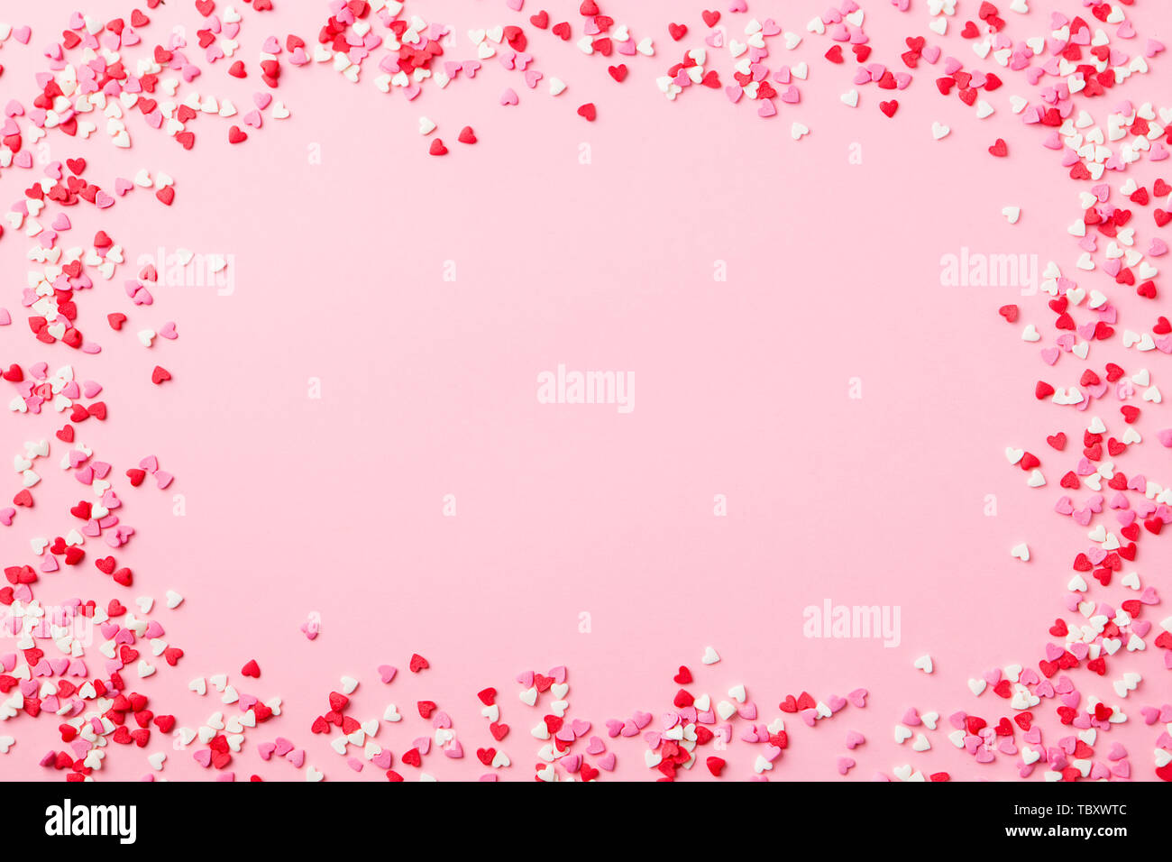 Zucker herzen Frame auf rosa Hintergrund. Romantisch, St Valentines Tag Konzept. Ansicht von oben. Kopieren Sie Platz. Stockfoto