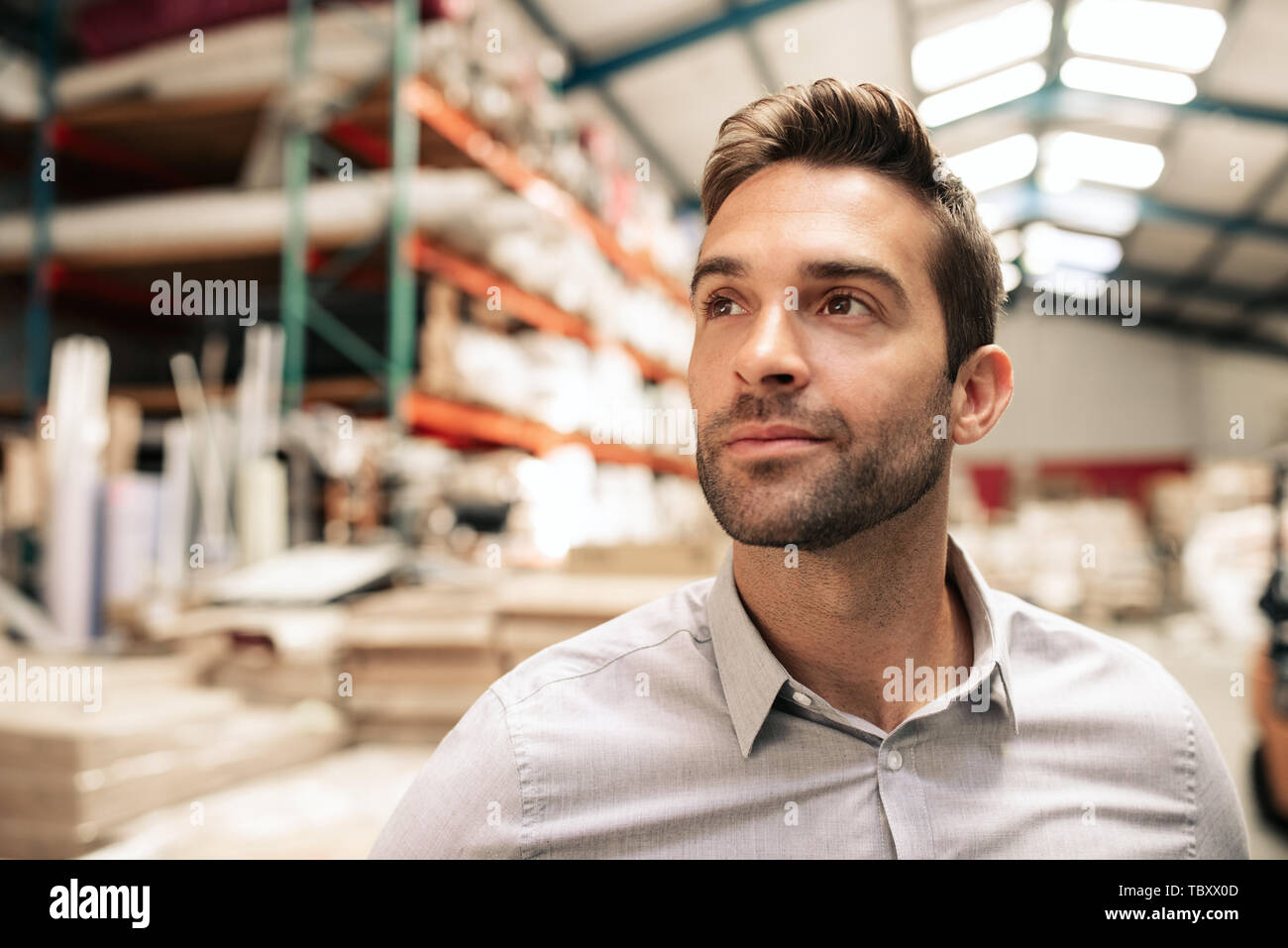 Manager auf Lager beim Stehen in einem grossen Lager Stockfoto