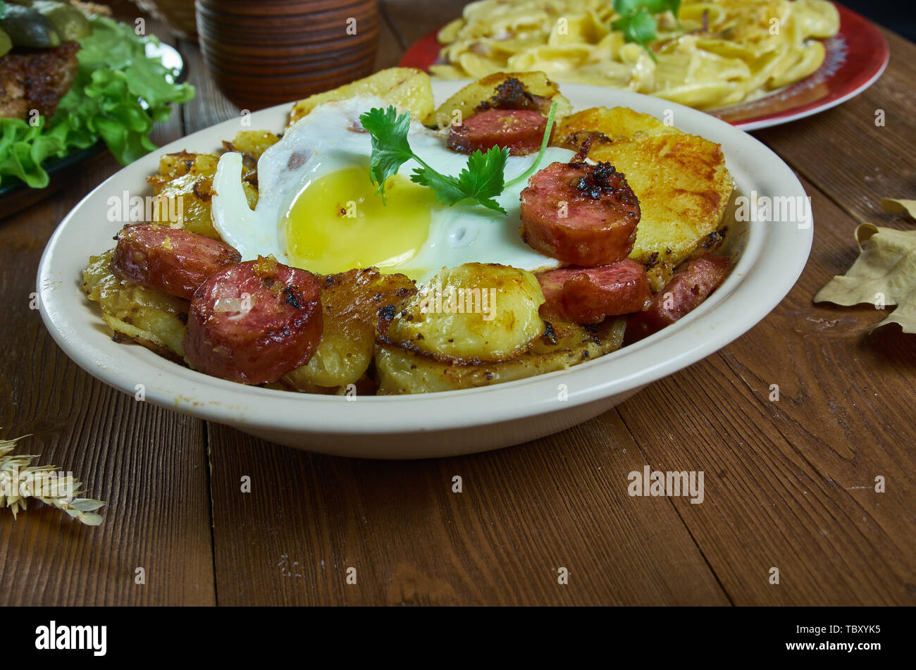 Tiroler Grostl, Bratkartoffeln, Speck und Zwiebeln. Österreichische Küche, Traditionelle verschiedene Gerichte, Ansicht von oben. Stockfoto