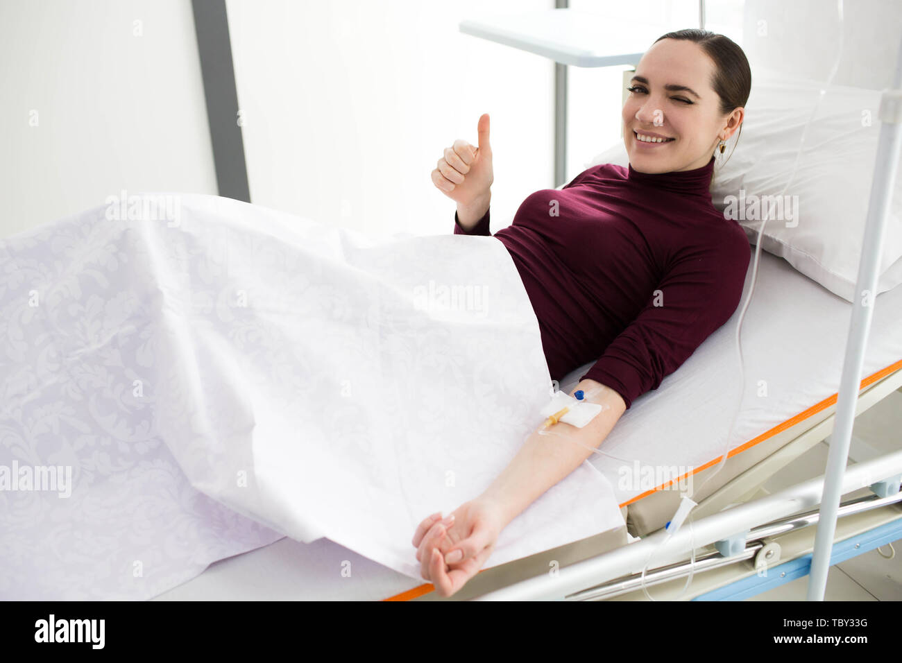 Frau im Krankenhaus Bett lag, Genesung, besseres Gefühl nach Infusion Behandlung Stockfoto