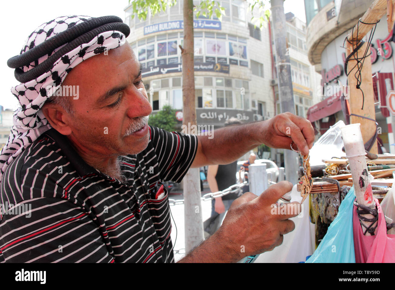 Ramallah, West Bank, Palästina. 3. Juni 2019. Palästinensischen mann Mosa al-Sahouri, 66, verkauft seine handgefertigten Holz- Geschenke, in der Straße vor dem Eid al-Fitr Urlaub, in der West Bank Stadt Ramallah, 03. Juni 2019. Al-Shahouri ist ein Analphabet Mann begann seine Erbe Beruf seit 50 Jahren schriftlich und Zeichnen auf Olivenholz und verkaufen für Einheimische und Touristen Credit: Ayat Arqawy/APA-Images/ZUMA Draht/Alamy leben Nachrichten Stockfoto