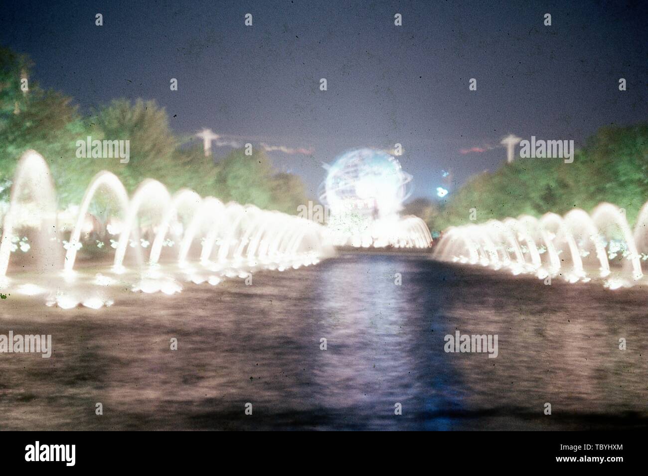 Blurry night-shot, der beleuchteten Brunnen Federn am Rande der Pool von Reflexionen und die beleuchtete Unisphere, 1964 in New York World's Fair, Flushing Meadows Park, Queens, New York, Juni, 1964. () Stockfoto