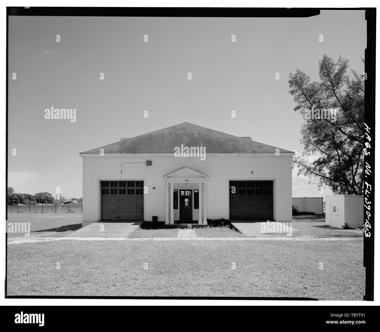 Norden ELEVATION. Gefahrgut LAGERSCHUPPEN IST SICHTBAR AUF DER RECHTEN SEITE. DOCKSIDE LAGERSCHUPPEN IST SICHTBAR IN DER FERNE. See wert EINLASS UND DIE STADT PALM BEACH SIND IM HINTERGRUND. U.S. Coast Guard See Wert am Bahnhof, Bootshaus, Peanut Island, Riviera Beach, Palm Beach County, FL Stockfoto