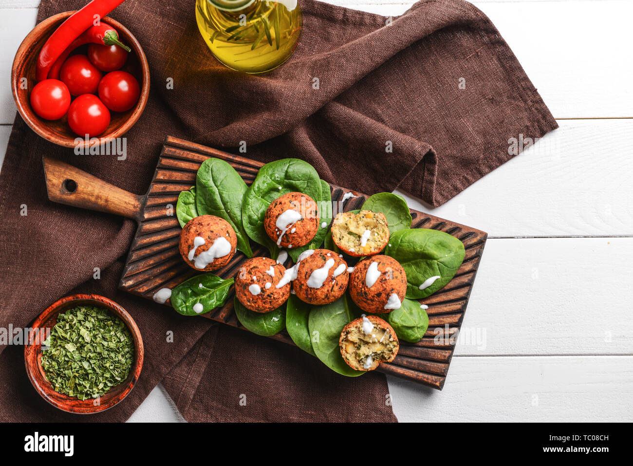 Vorstand mit leckeren Falafelkugeln und Spinat auf Tisch Stockfoto