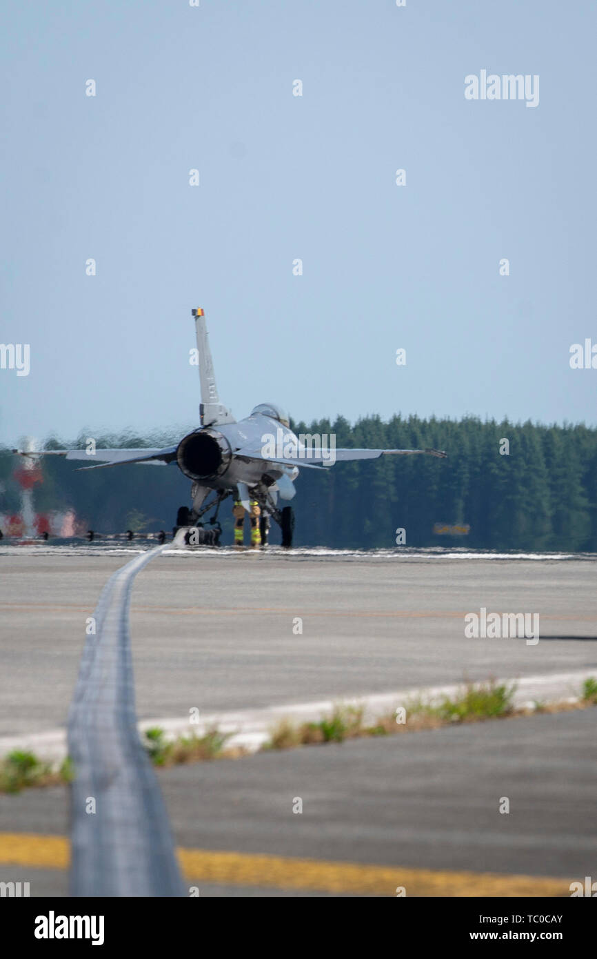Mitglieder der 374 Tiefbau Feuerwehr haken Sie eine Air Force F-16 Fighting Falcon von einem Flugzeug catch Kabel während einer jährlichen Zertifizierung Test des Flugzeugs Auffangsystem bei Yokota Air Base, Japan, 30. Mai 2019. Die AAS aktiviert eine Hydraulikpumpe, die komprimiert ein Bremsbelag das Flugzeug sicher zu langsam. (U.S. Air Force Foto von Airman 1st Class) Bolfing Brieana E. Stockfoto