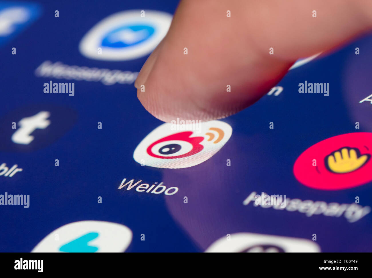 Finger drücken der Sina Weibo Symbol für das Chinesische microblogging App auf dem Touchscreen eines mobilen Geräts. Stockfoto