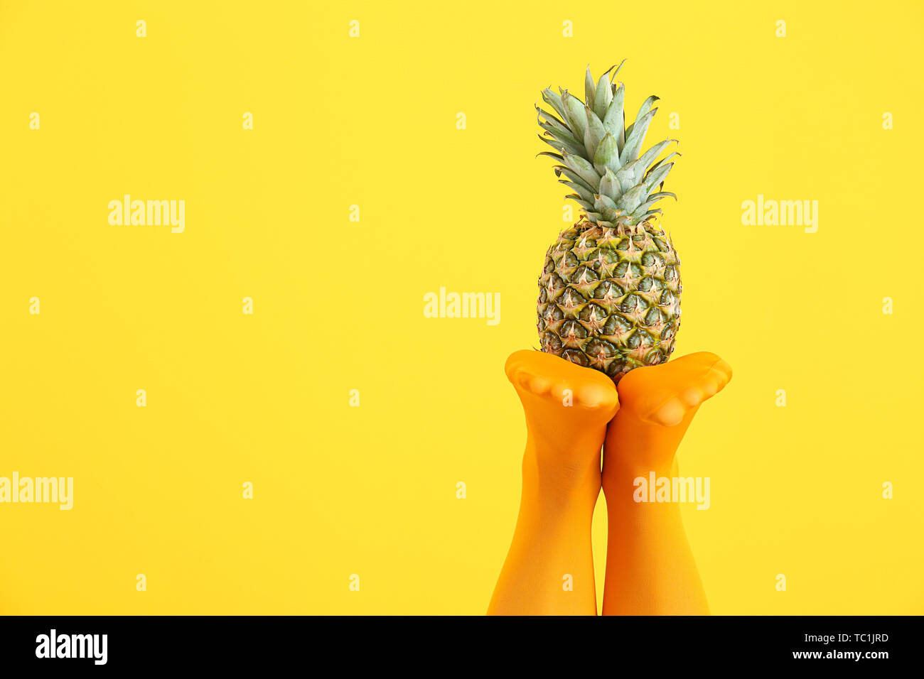 Beine der schöne junge Frau in Strumpfhosen und Ananas auf farbigen  Hintergrund Stockfotografie - Alamy