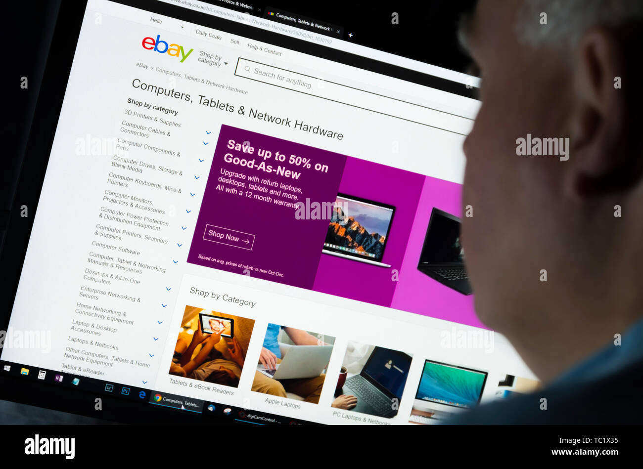 Mann, der an einem Computer Monitor Surfen durch das Internet auf der Ebay UK Web site auf dem World Wide Web über einen Internet Browser suchen. Stockfoto