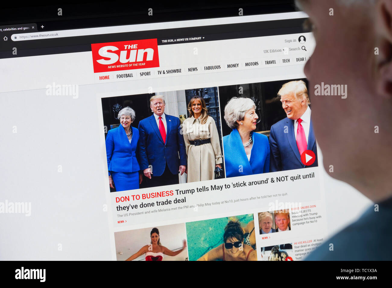 Mann, der an einem Computer Monitor Surfen durch das Internet auf die Sonne Zeitung Web site auf dem World Wide Web über einen Internet Browser suchen. Stockfoto