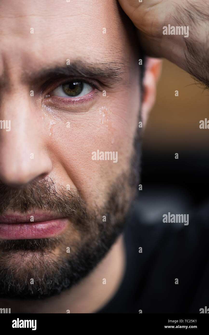 Teilweise mit Blick auf die weinenden Mann mit Tränen im Gesicht an der Kamera auf der Suche Stockfoto