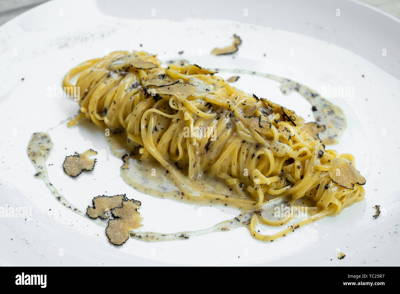 Nahaufnahme der Ein schwarzer Trüffelsauce frische tagliolini Nudel Pasta, original italienische Lebensmittel frisch Eierteigwaren handgefertigte isoliert, Chef's Table, Food Network, Stockfoto