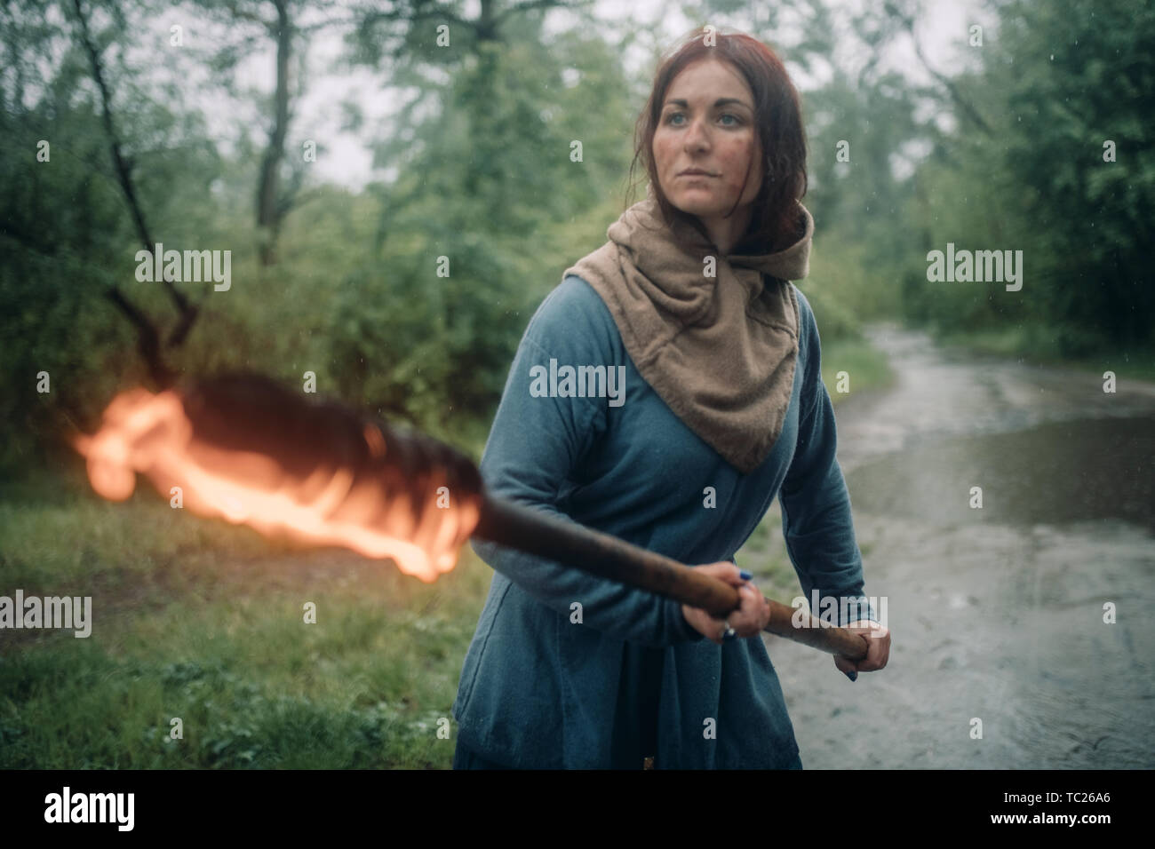 Das Mädchen auf dem Bild einer mittelalterlichen Kriegerin mit einer brennenden Fackel in der Hand ist die Vorbereitung um den Angriff abzuwehren. Stockfoto
