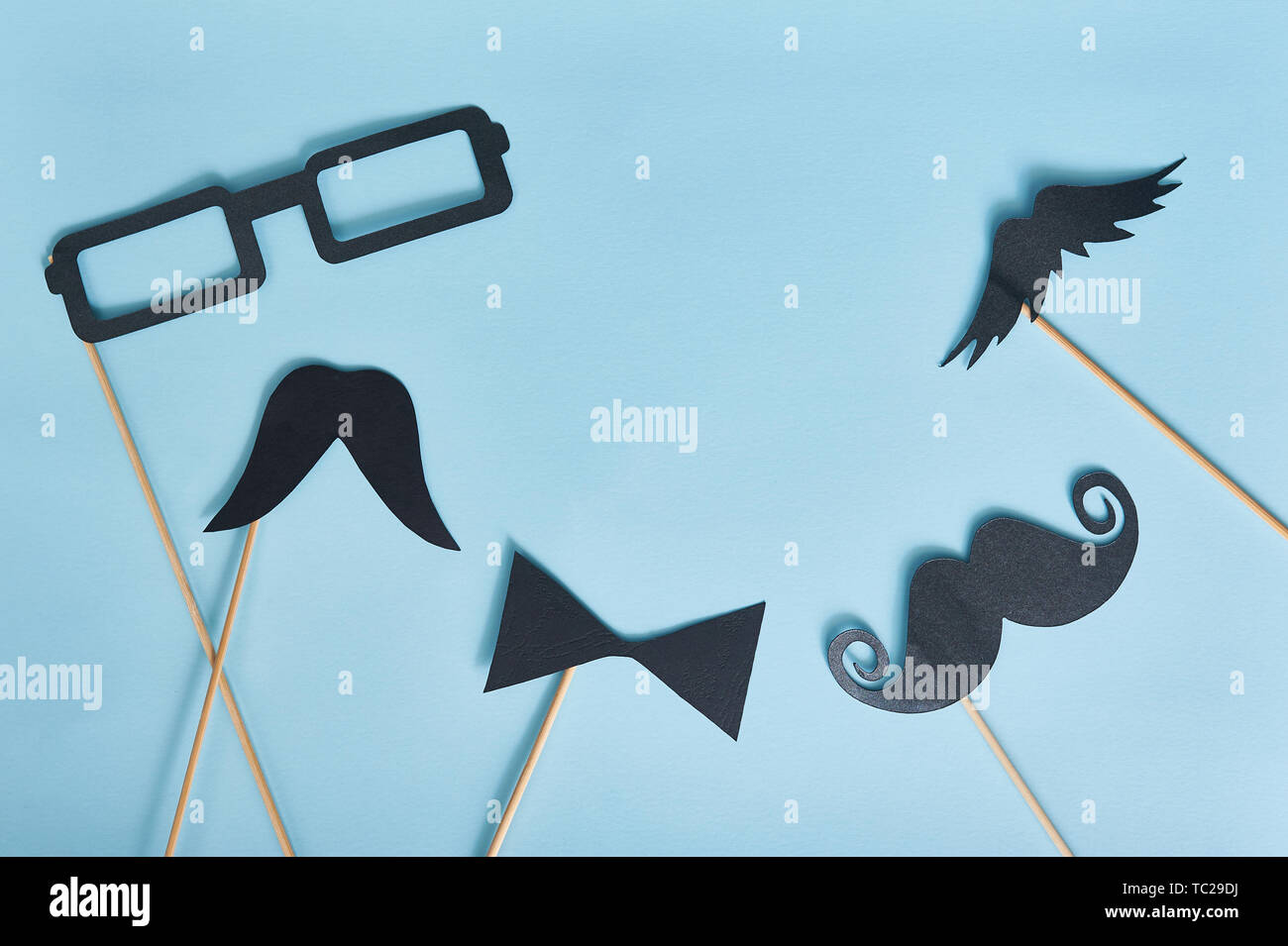 Dekorativer Mann Schnurrbart und schwarze Brille auf hellblauem Papierhintergrund. Draufsicht für Grußkarte mit Platz für Text. Glücklicher Vatertag flach Stockfoto
