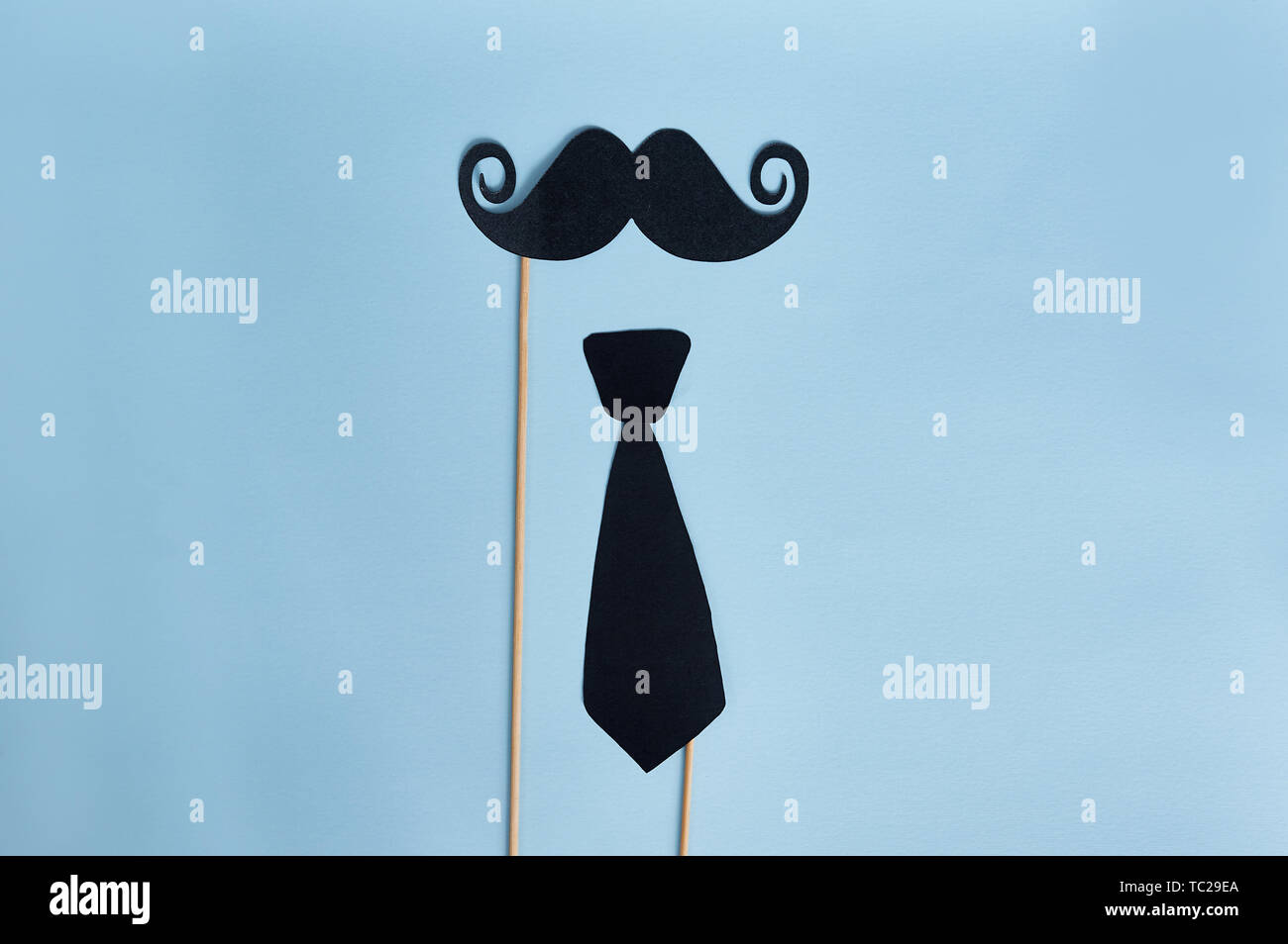 Glücklicher Vatertag. Dekorativer Mann Schnurrbart und Fliege auf hellblauem Holzhintergrund. Draufsicht Stockfoto