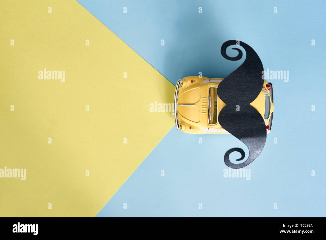 Kiiv, Ukraine - 6. Juni 2019: Vatertag-Grußkarte mit gelbem Spielzeugauto und schwarzem Papierbart auf blauem Hintergrund mit Platz für Ihren Text Stockfoto