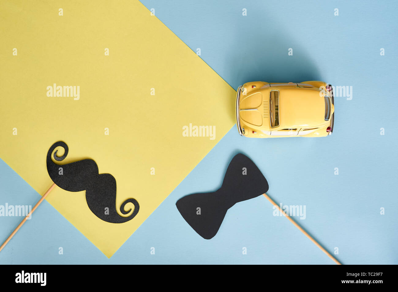 Kiiv, Ukraine - 6. Juni 2019: Vatertag Grußkarte mit gelbem Spielzeugauto und schwarzem Papierbart und Krawatte auf blauem Hintergrund mit Platz für Ihre Stockfoto