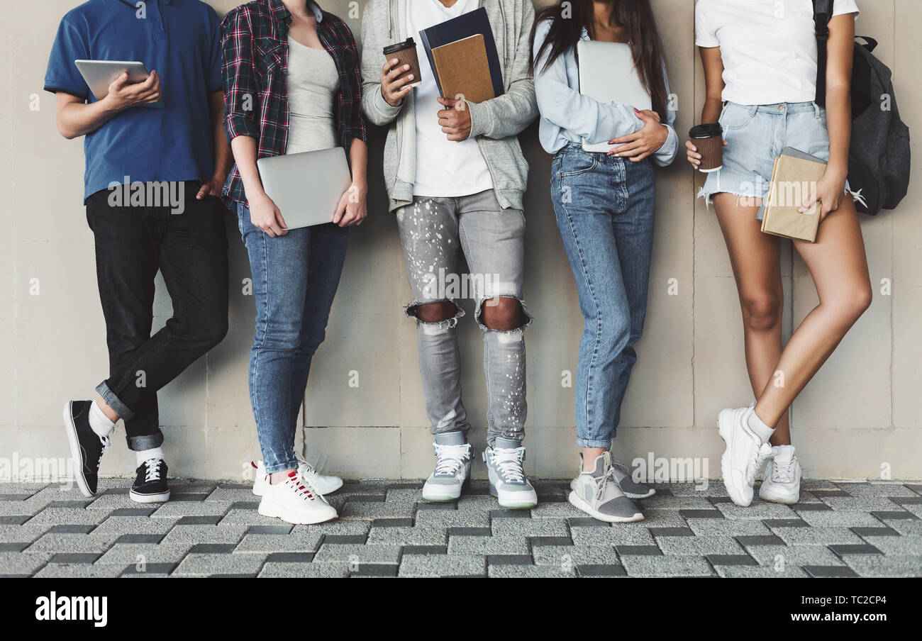 Gruppe von verschiedenen Jugendlichen posiert mit Gadgets und Bücher Stockfoto