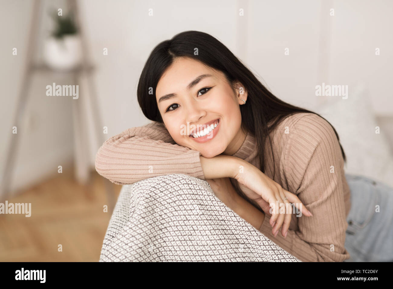 Gerne asiatische Mädchen entspannen im Wohnzimmer Stockfoto