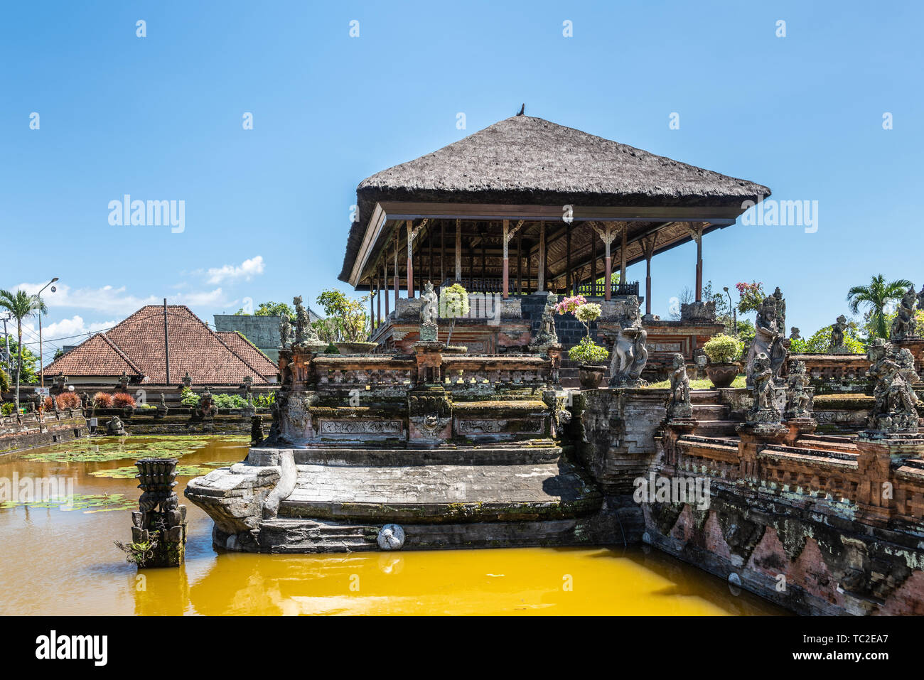 Klungkung, Bali, Indonesien - Februar 26, 2019: braun Stein schwebenden Pavillon Royal Palace von Klungkung Königreich mit grauen Reed Dach unter blauem Himmel. Stockfoto