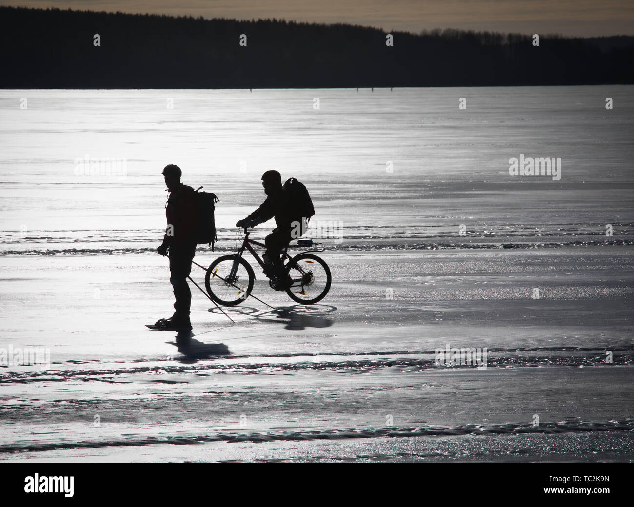 Radfahrer und Skater auf Eis gefrorenen See Malaren, Schweden, Skandinavien Silhouette Stockfoto